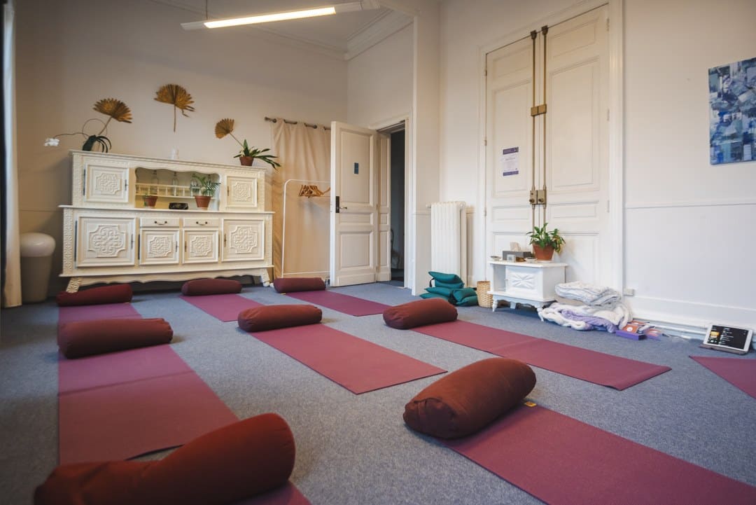Salle préparée avant l'arrivée du groupe : tapis et coussins alignés